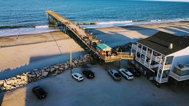 Aerial view of the Carolina Beach pier and oceanfront at sunset