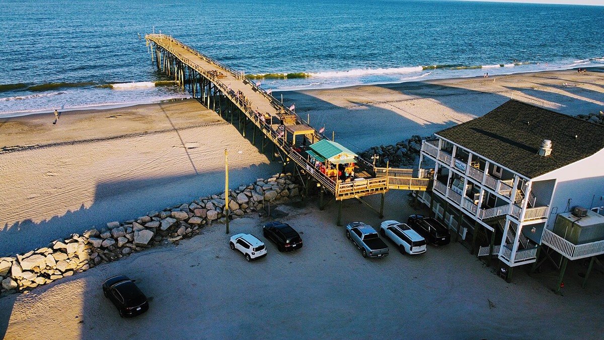 Aerial view of the Carolina Beach pier and oceanfront at sunset