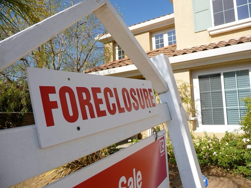 Foreclosure sign posted in front of a family home