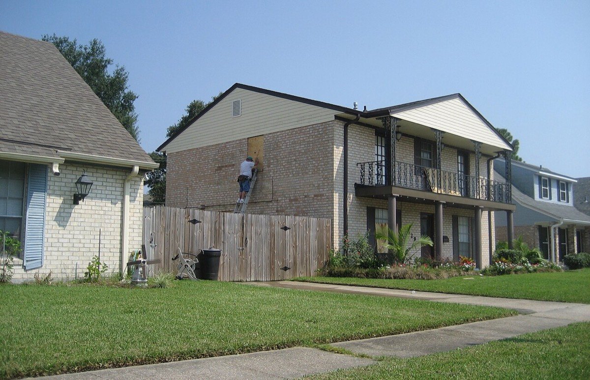 Homeowner boarding windows ahead of a hurricane
